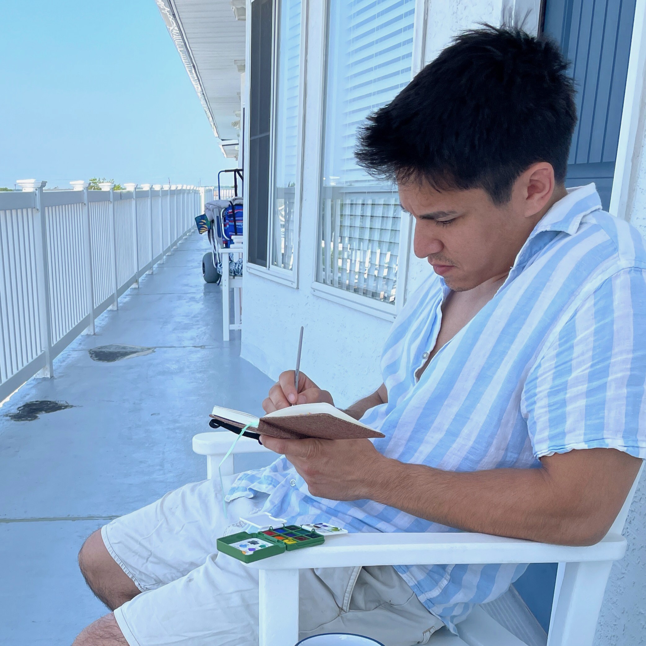 Jon painting on a balcony